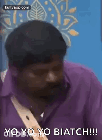 Man In Purple Shirt Talking In Front Of Blue Wall GIF