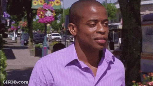 Man In Purple Shirt Walking Down Street GIF