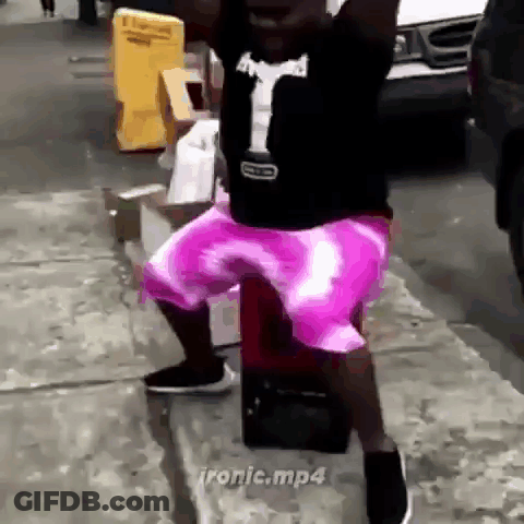 Man In Purple Shorts Standing On Sidewalk GIF
