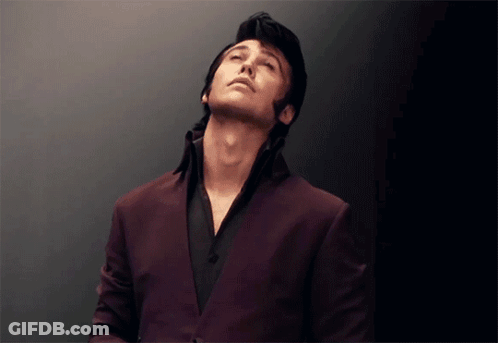 Man In Purple Suit And Black Shirt Looking Up GIF
