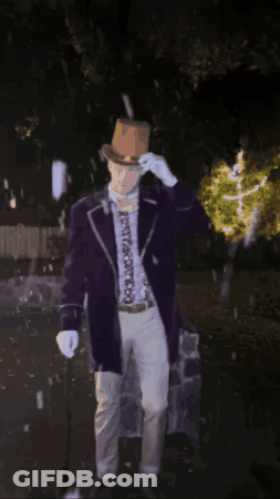 Man In Purple Suit And Brown Hat Standing In Dark GIF