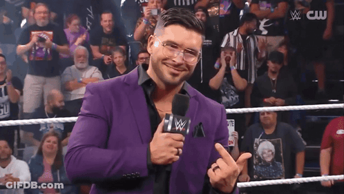 Man In Purple Suit Holding Microphone GIF
