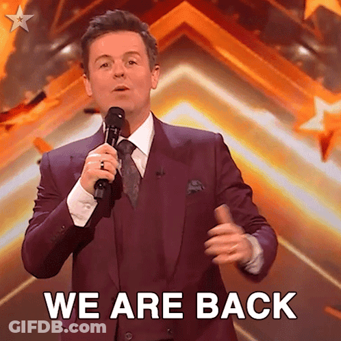 Man In Purple Suit Holding Microphone Saying We Are Back GIF