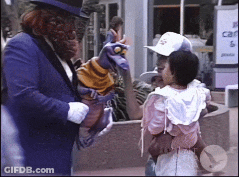 Man In Purple Suit Holding Puppet Talking To Little Girl GIF