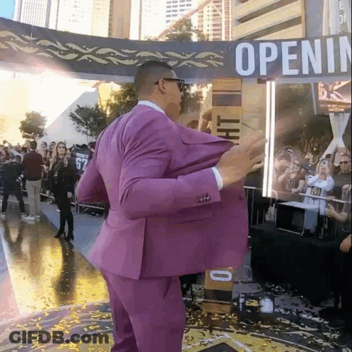 Man In Purple Suit In Front Of Open Sign GIF