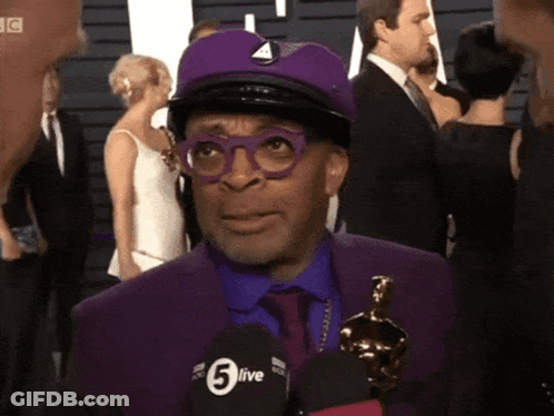 Man In Purple Suit Talking Into 5Live Microphone GIF