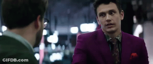 Man In Purple Suit Talking To Man In Green Shirt GIF