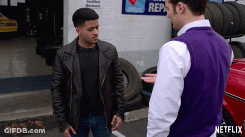 Man In Purple Vest Talking To Man In Front Of Certified Mechanic Sign GIF