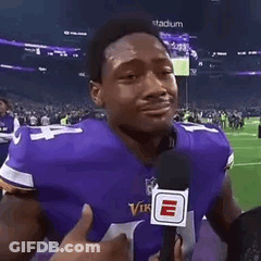 Man In Purple Vikings Jersey Holding Microphone Crying On Football Field GIF