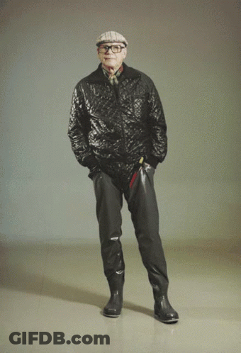 Man In Quilted Jacket And Hat With Hands In Pockets GIF