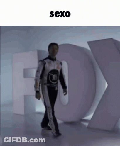 Man In Race Suit Walking Past Fox Sign GIF