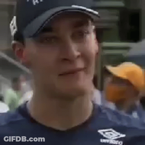 Man In Racing Hat Smiling Holding Head GIF