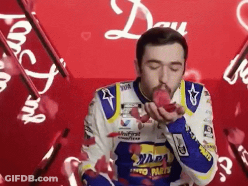Man In Racing Suit Blowing Kiss GIF