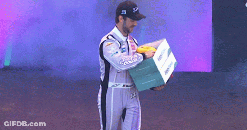 Man In Racing Suit Holding Foodie Box GIF