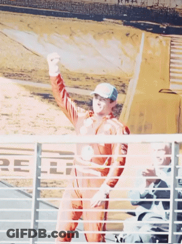 Man In Racing Suit Raising Fist GIF