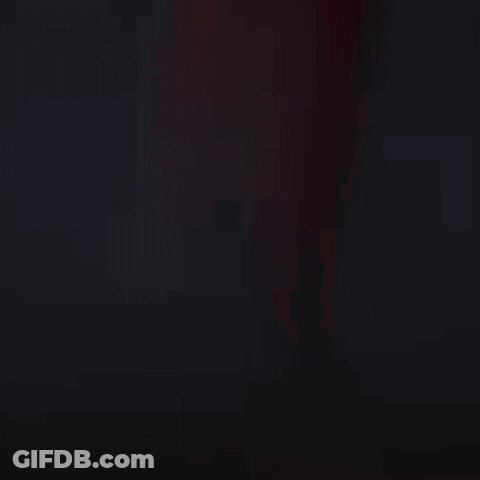 Man In Racing Suit Standing In Front Of Car In Dark GIF