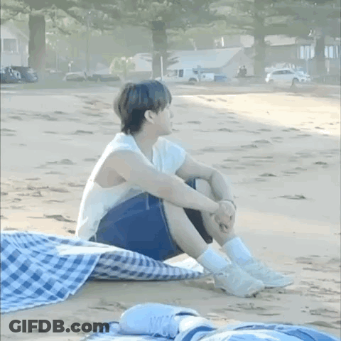 Man In Racing Suit Standing In Front Of Couch Saying Sit On It And Do Tricks GIF