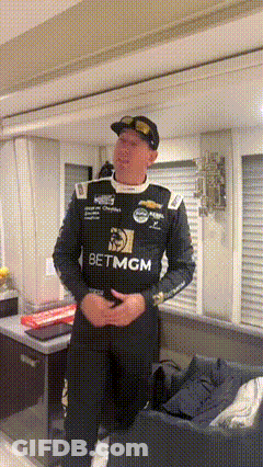 Man In Racing Uniform In Living Room GIF