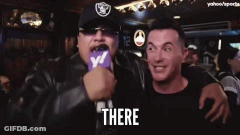 Man In Raiders Hat Holding Microphone Saying There GIF