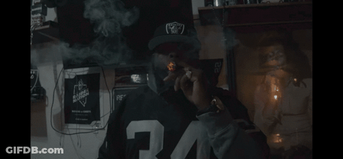 Man In Raiders Hat Smoking GIF