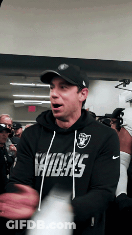 Man In Raiders Sweatshirt Standing In Crowd GIF