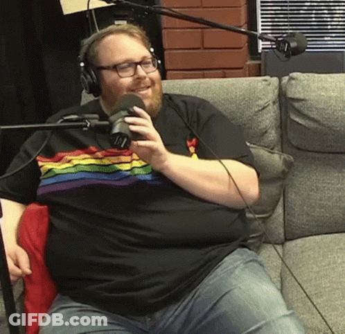 Man In Rainbow Shirt Talking Into Microphone GIF