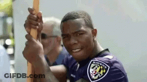 Man In Ravens Shirt Holding Stick GIF