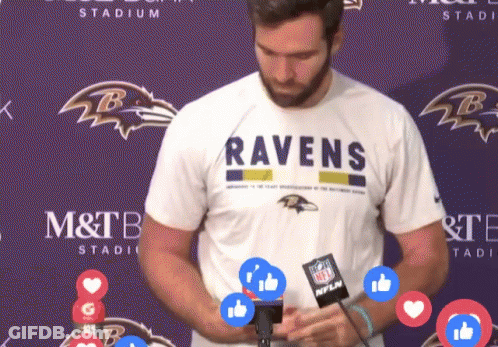 Man In Ravens Shirt In Front Of Purple Wall GIF