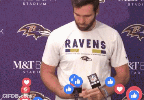 Man In Ravens T-Shirt In Front Of Purple Backdrop GIF
