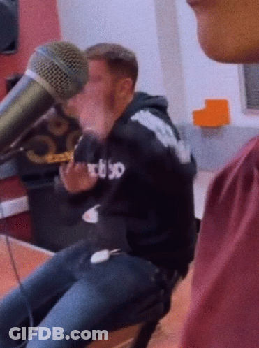Man In RBSO Hoodie Talking Into Microphone GIF