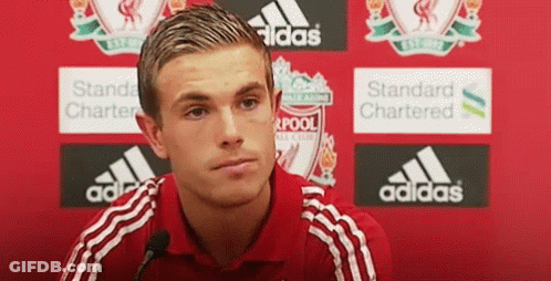 Man In Red Adidas Shirt Sitting In Front Of Red Wall GIF