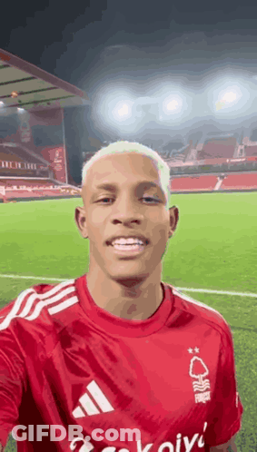 Man In Red Adidas Shirt Taking Selfie At Soccer Field GIF