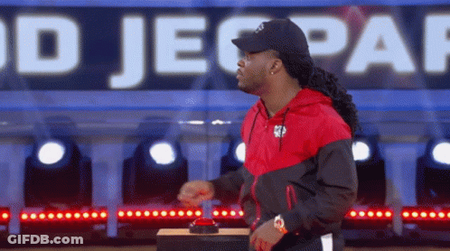 Man In Red And Black Jacket Pressing Jeopardy Button GIF