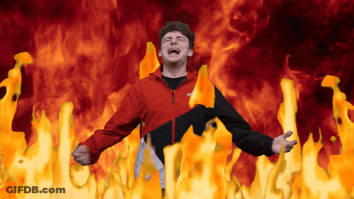 Man In Red And Black Jacket Surrounded By Fire GIF