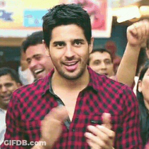 Man In Red And Black Plaid Shirt Clapping In Crowd GIF