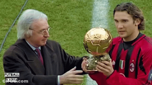 Man In Red And Black Shirt Holding Futbol Karim Trophy GIF