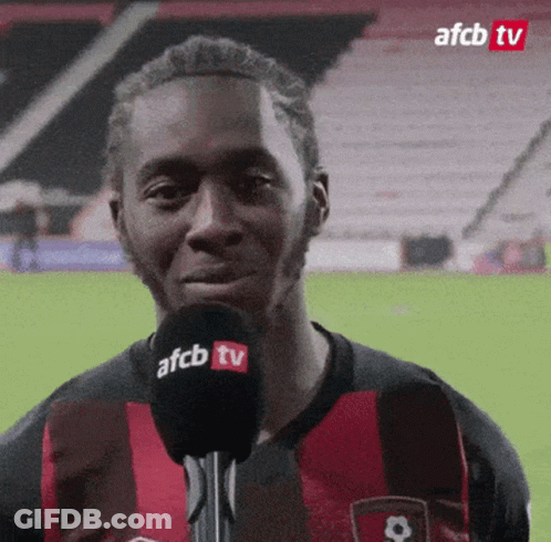 Man In Red And Black Shirt Talking Into Microphone GIF