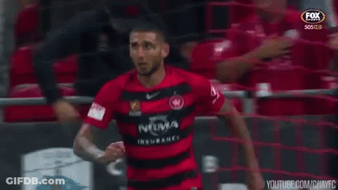 Man In Red And Black Soccer Jersey By Fence GIF