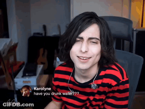 Man In Red And Black Striped Shirt Asking Karolyne If He Is Drunk GIF