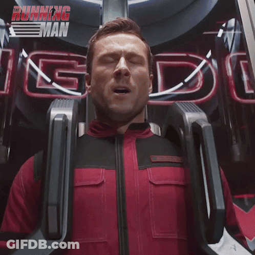 Man In Red And Black Suit Riding Roller Coaster With Running Man Sign GIF