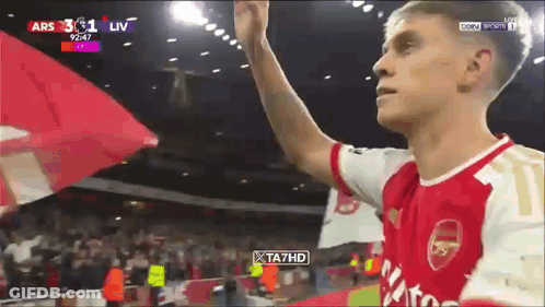 Man In Red And White Arsenal Jersey Holding Flag GIF