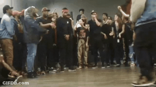 Man In Red And White Hat Dancing Beside Woman Lying On Floor GIF