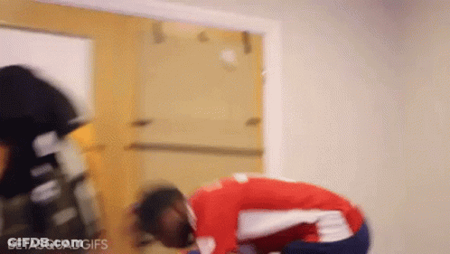 Man In Red And White Shirt Kneeling Before Door GIF