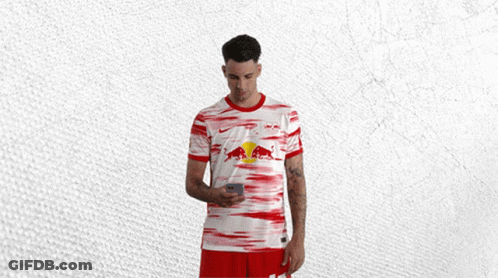 Man In Red And White Shirt With Red Bull Looking At Phone GIF