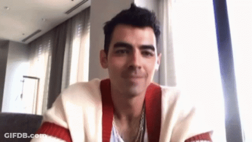 Man In Red And White Striped Sweater Sitting By Window GIF