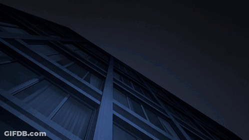 Man In Red And White Suit Hanging From Building At Night GIF