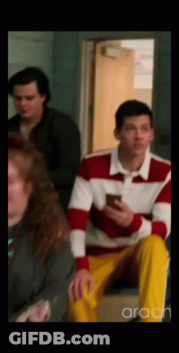 Man In Red And White Sweater Looking At Phone GIF
