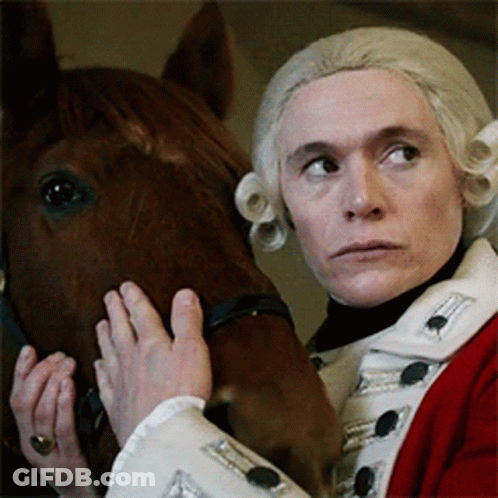 Man In Red And White Uniform Holding Brown Horse GIF