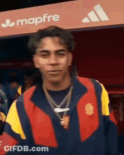 Man In Red And Yellow Jacket In Front Of Mapfre Sign GIF