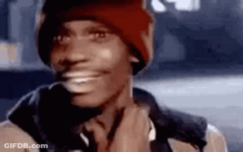 Man In Red Beanie And Brown Jacket Smiling Touching His Neck GIF